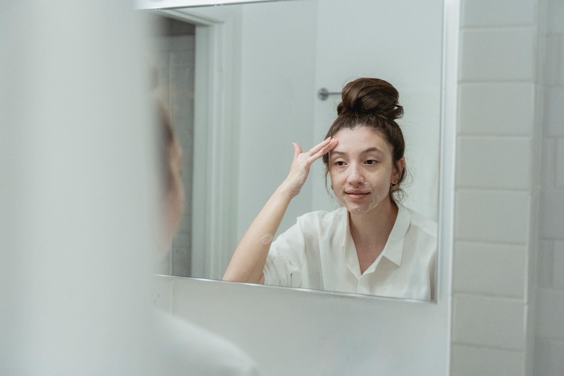 Wanita menyapu krim wajah dalam rutin pagi